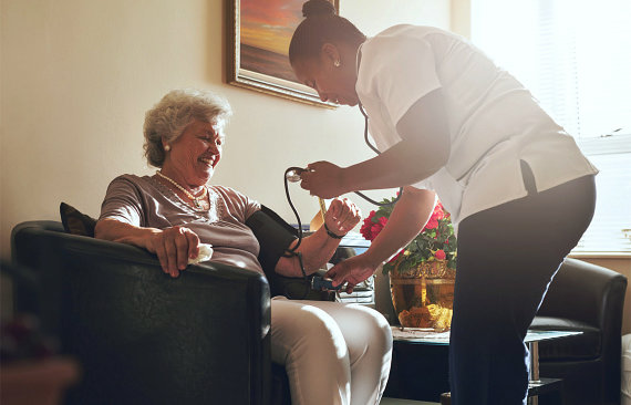 nurse checking a blood pressure of a senior woman